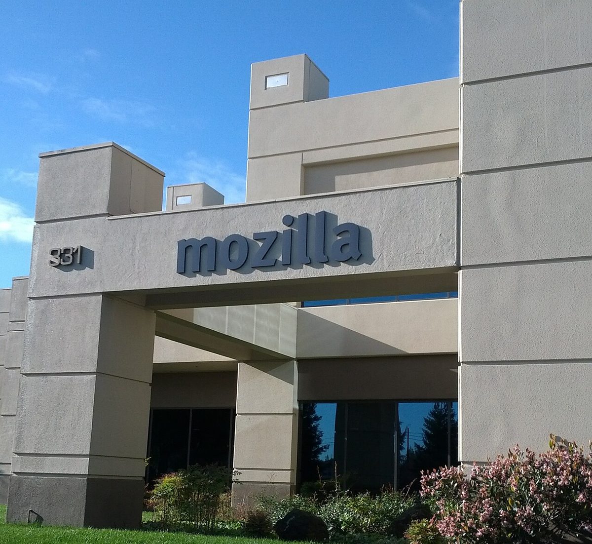 A pale concrete office building with the word mozilla in large letters over the entrance and the number 331 beside it, under a blue sky