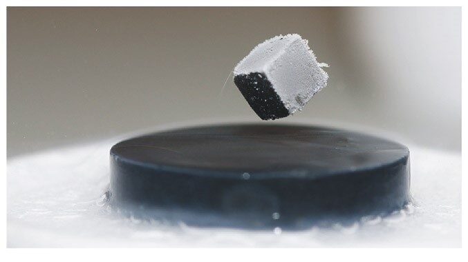 A small magnet floating in the air above a superconducting disk cooled with liquid nitrogen.